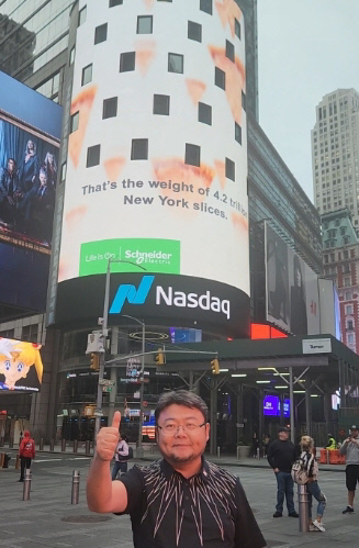 황요섭 케이팝모터스 총괄 회장이 나스닥증권거래소 앞에서 화이팅을 외치고 있다.